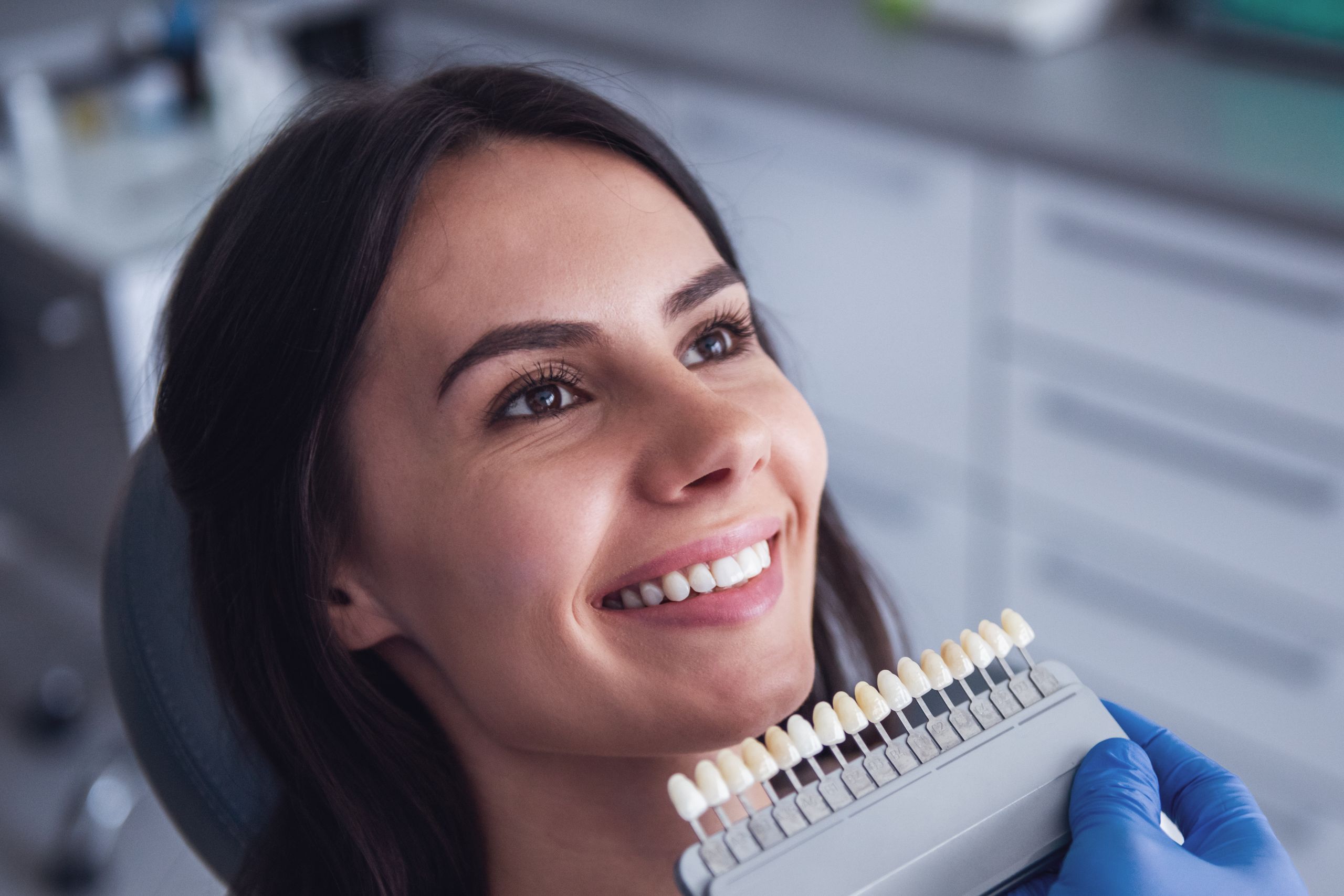 The girl is going through the procedure a veneers shade analysis to look like she has natural teeth
